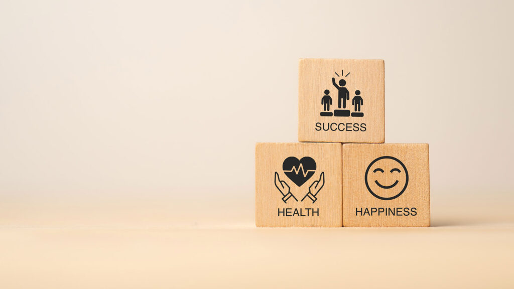 Three wooden blocks with health, happiness and success