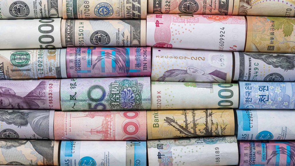 Photograph of folded cash from a plethora of different currencies.